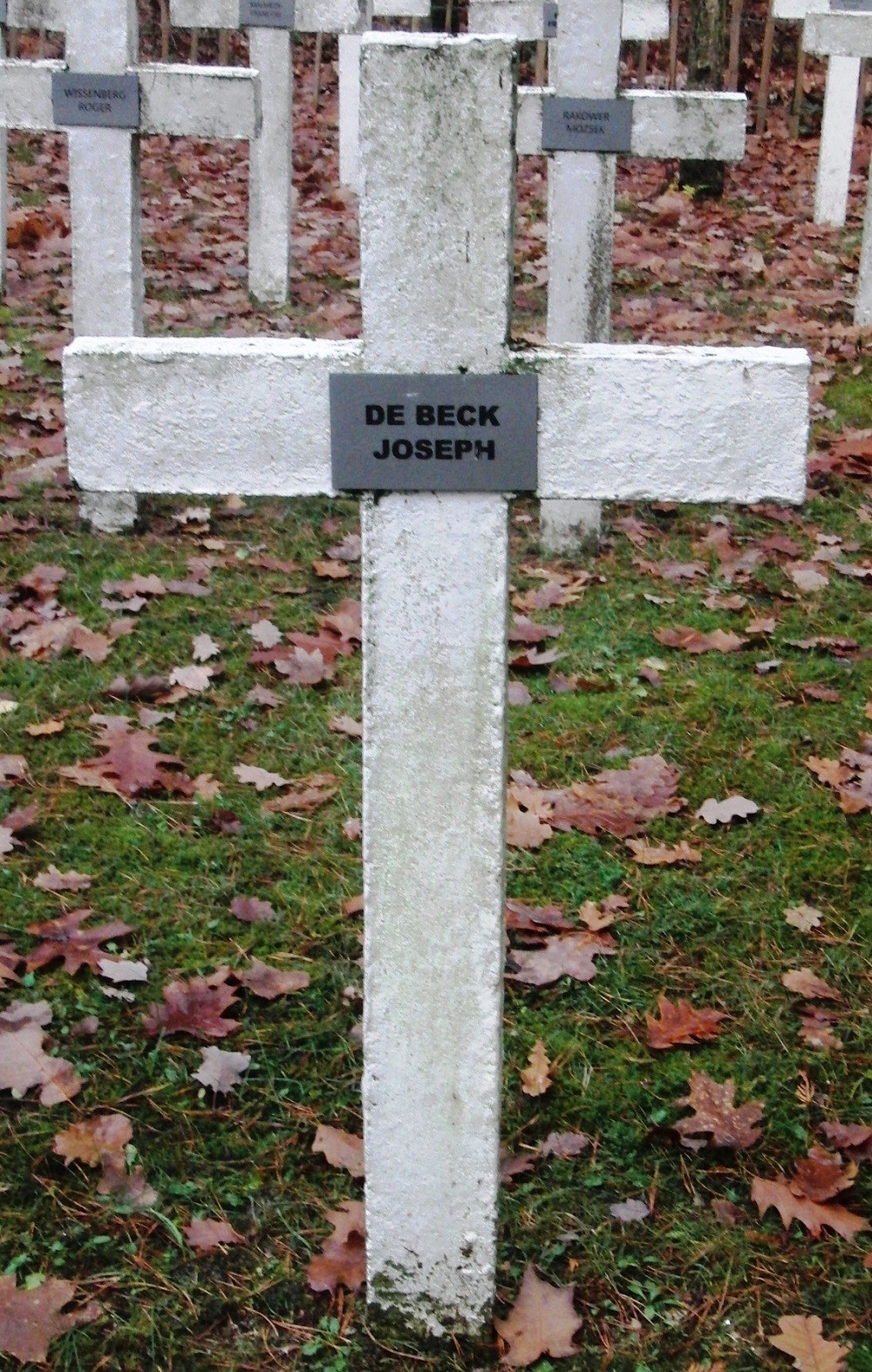Witte kruisgrafsteen met naamplaatje