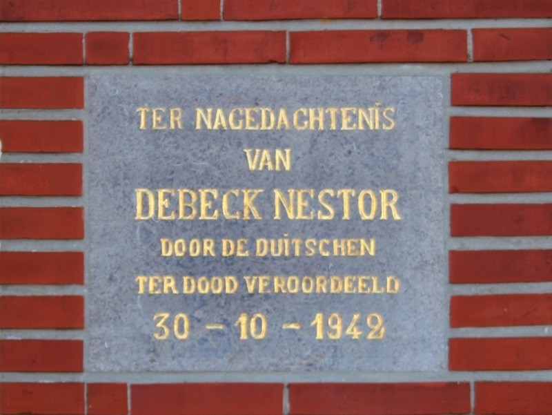 Gedenksteen voor Debeck Nestor, ter dood veroordeeld door de Duitsers op 30-10-1942, gemonteerd in een bakstenen muur.