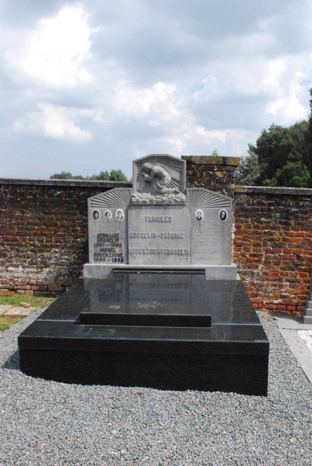 Grafsteen van de families Gosselin-Sadoine en Bouckzoone-Gosselin met een beeld van een biddend figuur.