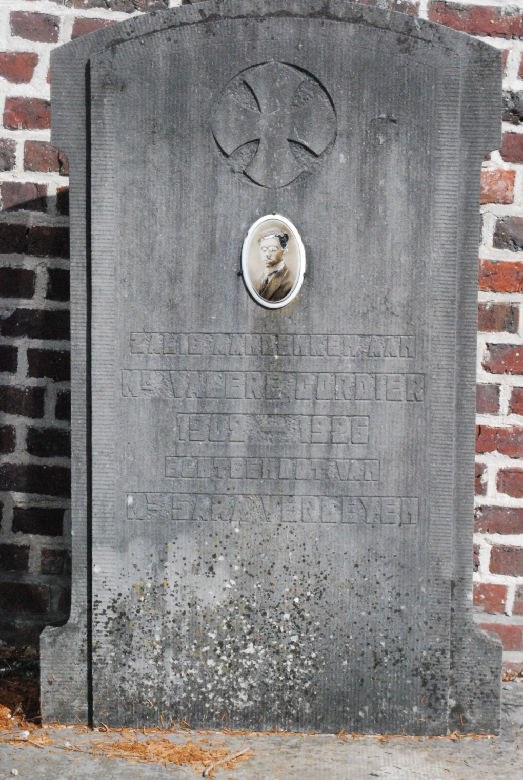 Grafsteen van N.S. Valère Cordier (1849-1926) met een kruis en een zwart-wit portretfoto.